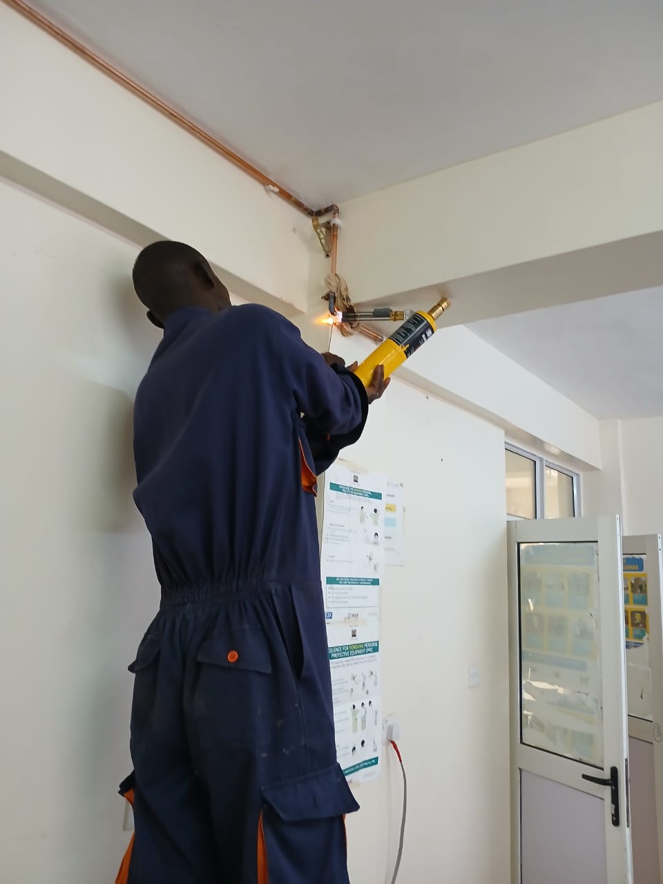 Technician brazing medical gas copper pipeline overhead