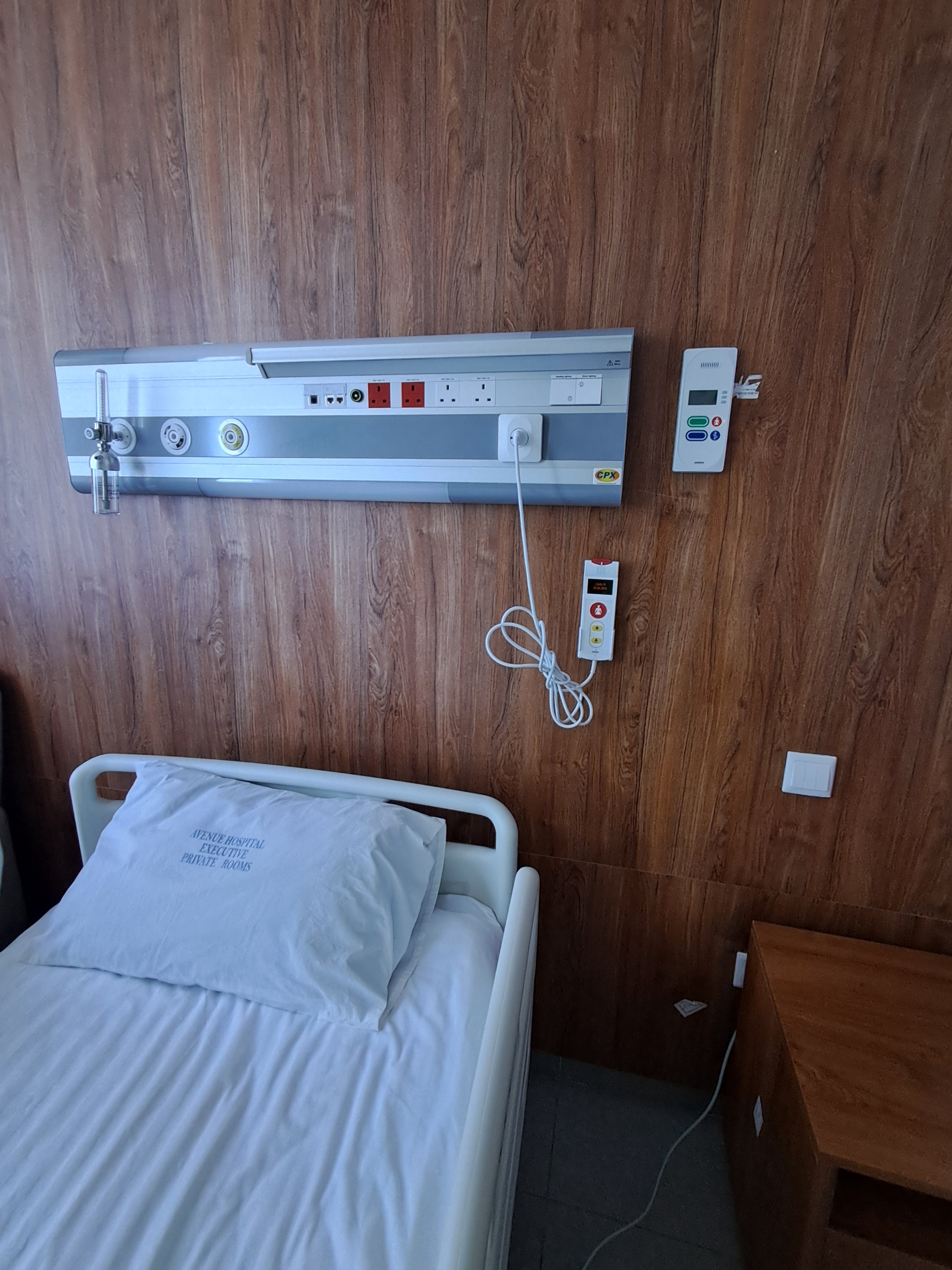 Wood-panelled ward room with bed head unit and nurse call handset