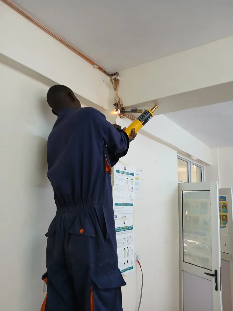 Technician brazing medical gas copper pipeline overhead